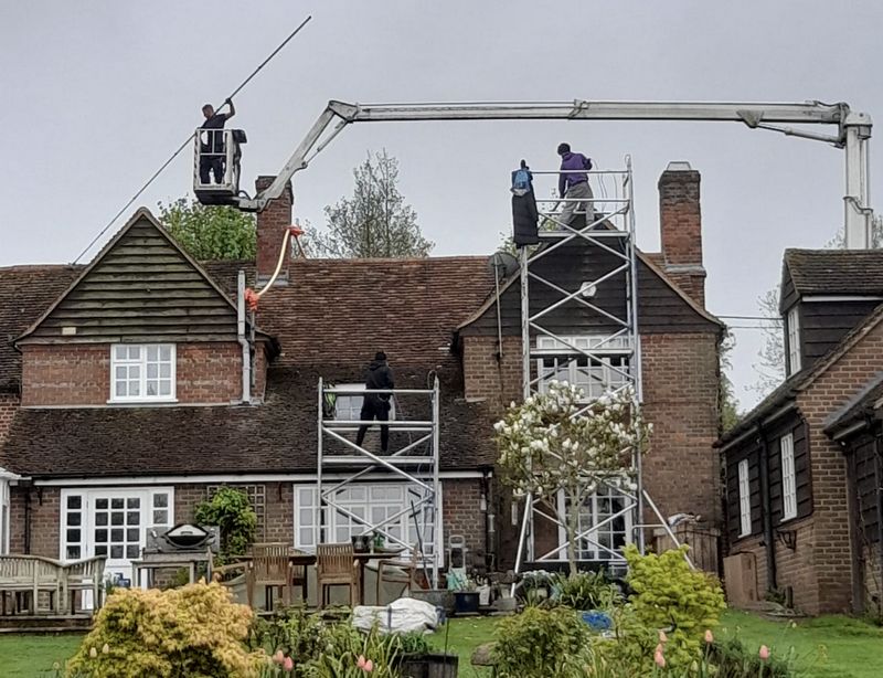 The Moss Cleaners using cherry picker and scaffolding to clean roof safely and professionally in Storrington, West Sussex
